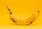Ripe banana on yellow background.